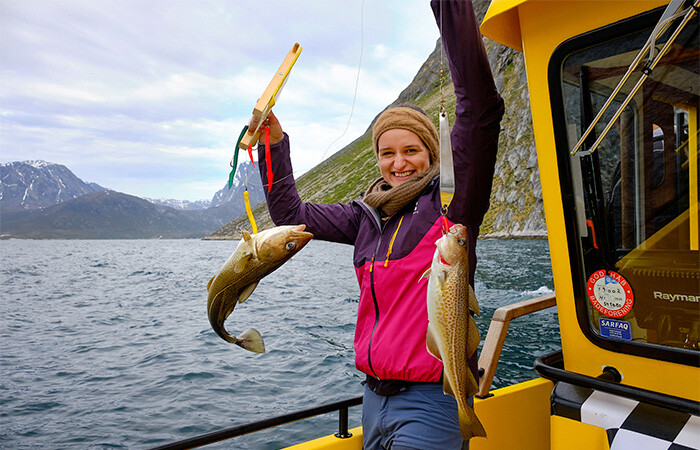 A happy woman who has just captured two fish.